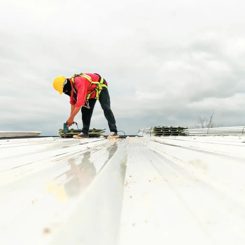 Roofer placing metal roof.