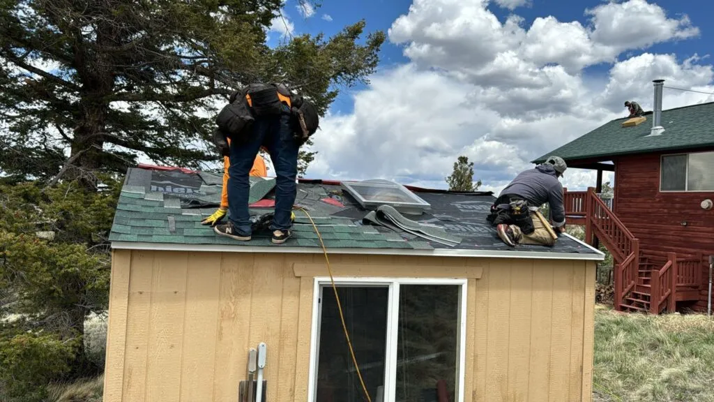 shingle roof replacement in process in colorado with green colored shingles