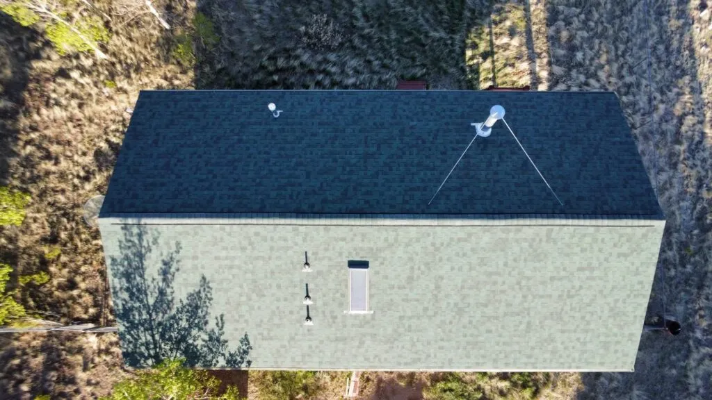drone shot of an after roof replacement of a green shingle roof