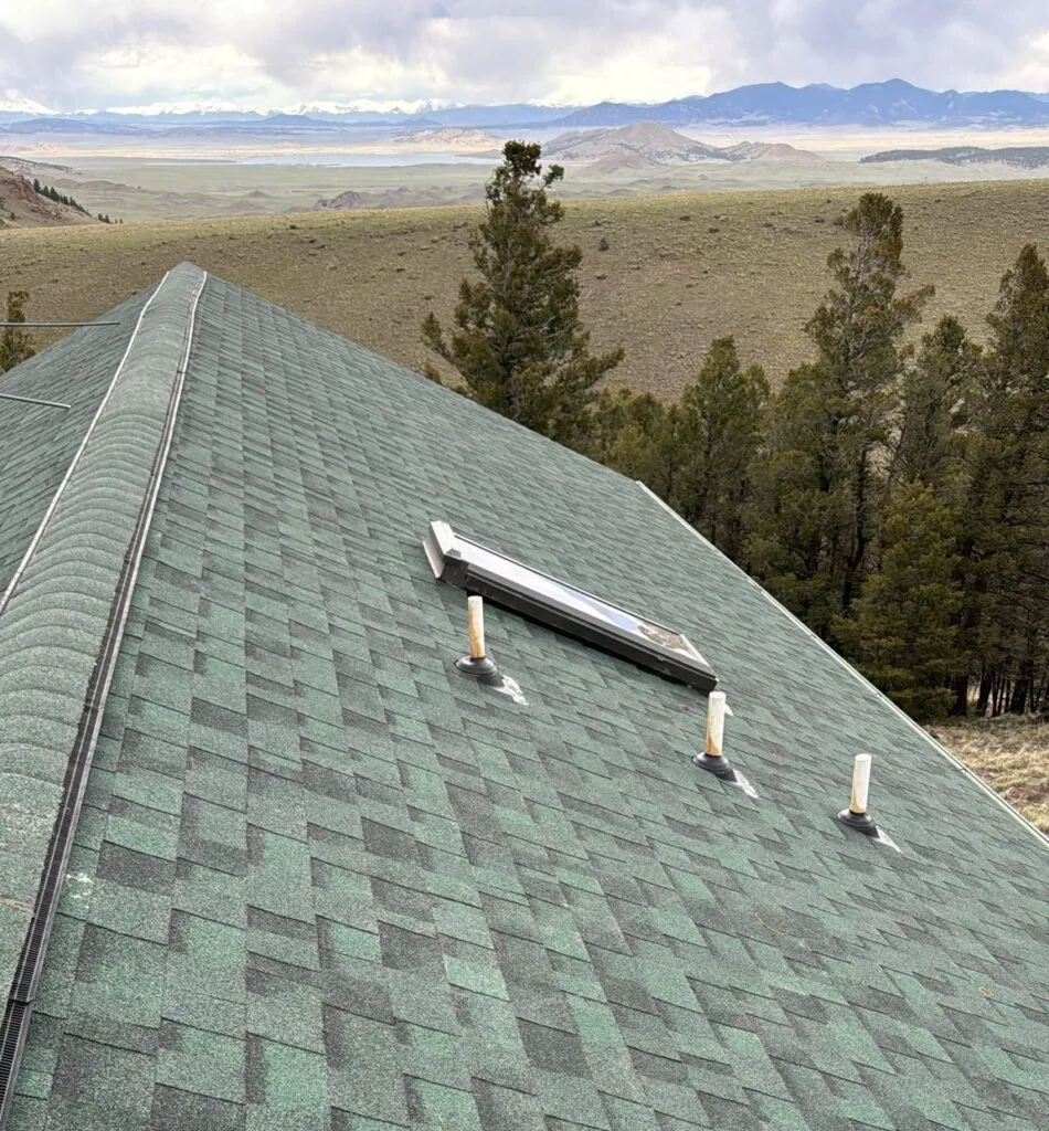 new green shingle roof on home in colorado with a skylight overlooking the mountains in the distance