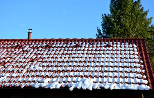 snow on a tile roof in winter