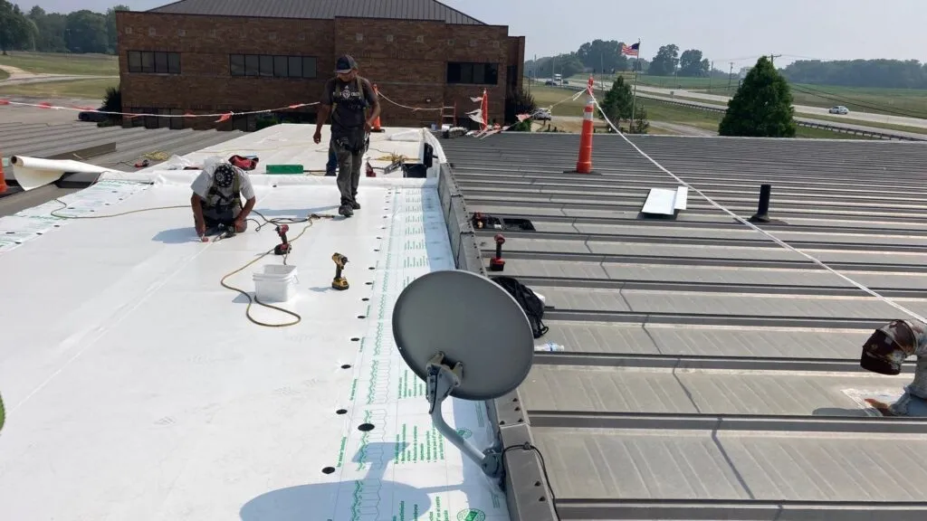 commercial metal roof replacement in process with expert roofers installing the roof